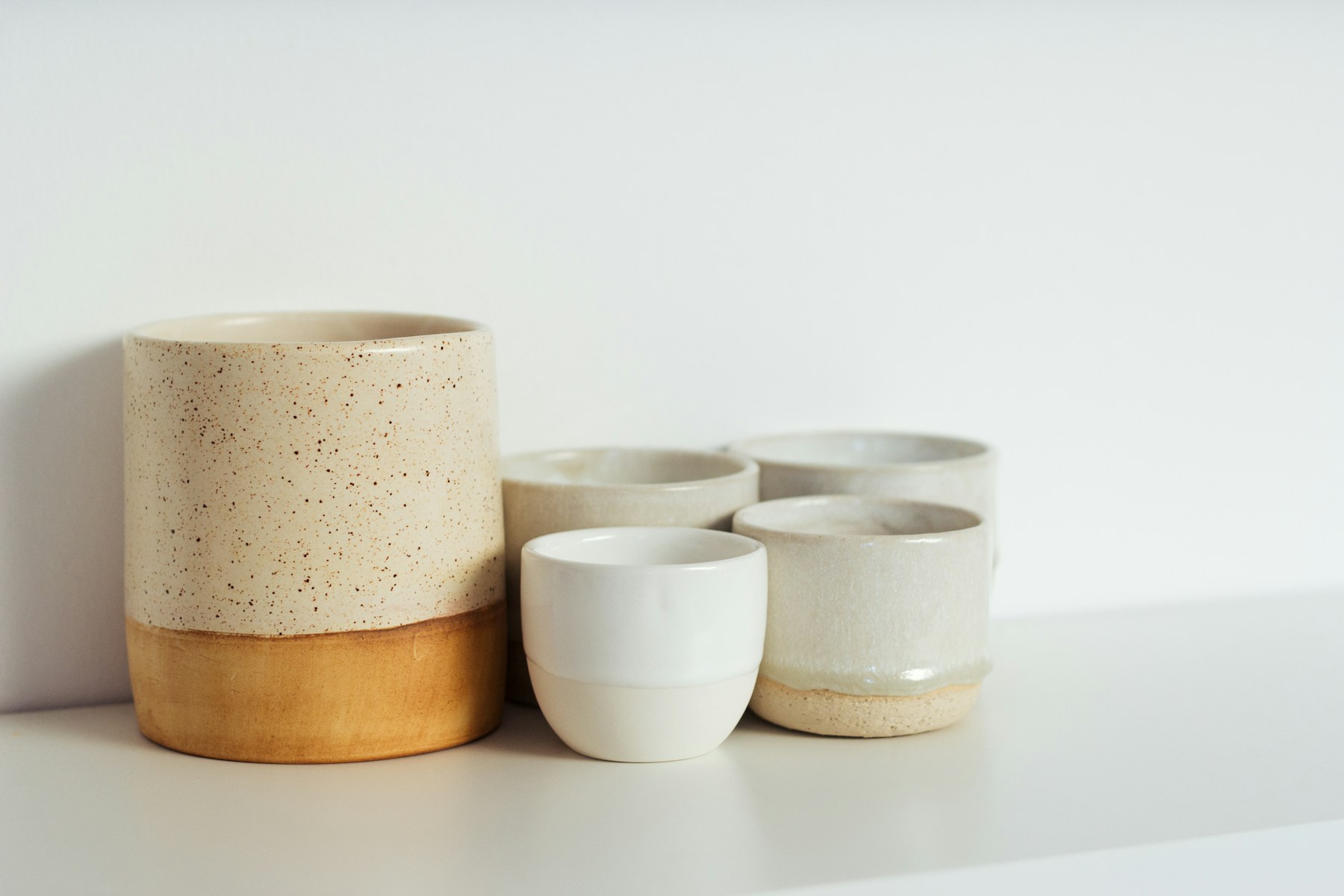 Stacked ceramic cups and bowls on a pale surface