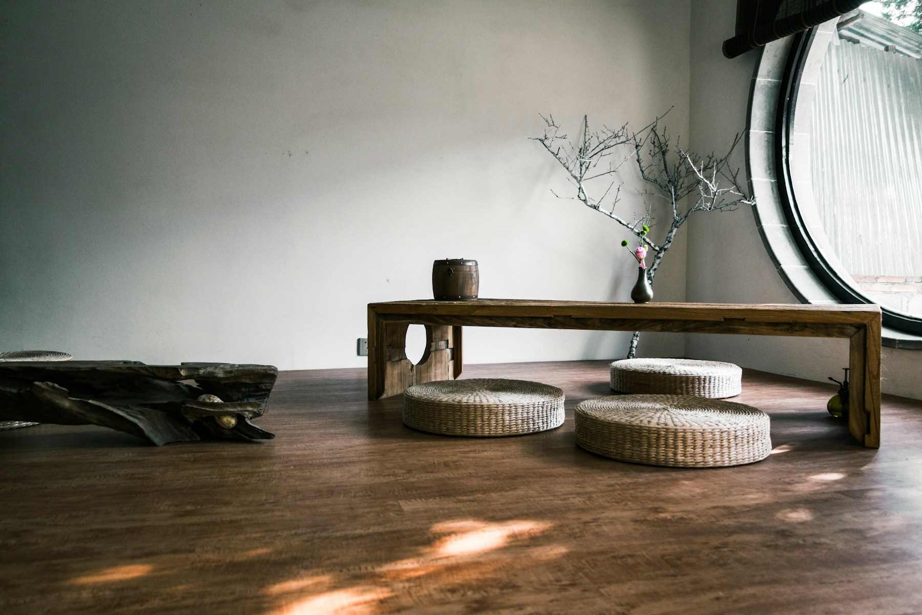 A low wooden bench by a round window